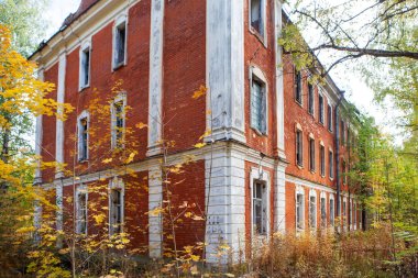 Arka planda karla kaplı, büyük ve kirli bir tuğla duvarın terk edilmiş eski binası..