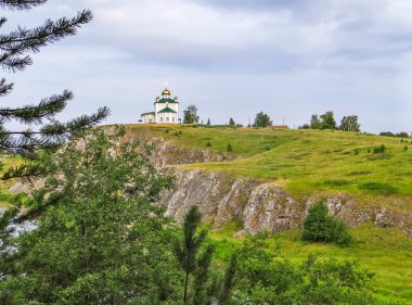 Tepedeki küçük kilise manzarası bulutlu gökyüzü, Aramashevo, Rusya
