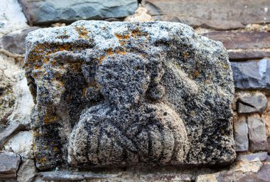 Tkhab-Yerdy tapınağının batı cephesinin taşında sakallı bir adam ve bir piskopos resmi var. Ingushetia Cumhuriyeti, Rusya. 15 Mayıs 2021