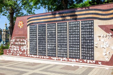 Beyaz güvercinler ve ölülerin fotoğraflarıyla dolu bir savaş anıtı. Pyatigorsk 'ta. Stavropol bölgesi. - Rusya. 21 Mayıs 2021