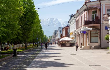 Prospekt Mira 'daki yayalar Masa Dağı manzaralı. Hughkavkaz, Kuzey Osetya, Rusya. 13 Mayıs 2021