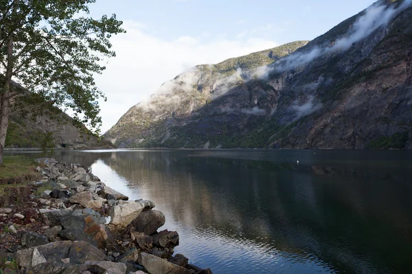 Sakin suda taş yansıma kayaları ile birleştirir. Sognefjord. Laerdal. Norveç. — Stok fotoğraf