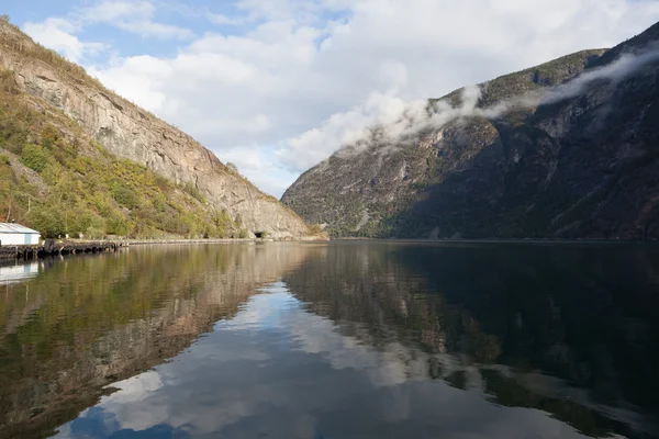 Die Reflexion der Felsen in ruhigem Wasser verschmilzt mit den Felsen selbst. sognefjord. laerdal. Norwegen. — Stockfoto