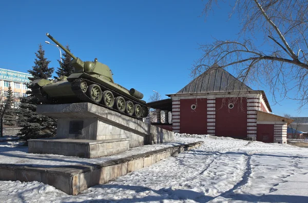 Tank "T-34" di latar belakang toko makanan kelas atas. 3 Maret 2015. Nizhny Tagil. Wilayah Sverdlovsk. Rusia . — Stok Foto