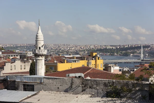 The minaret of a mosque Samani Virani and the Golden Horn metro bridge. Istanbul. Turkey.