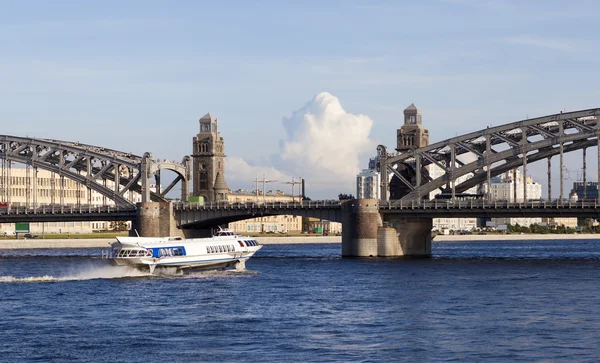 背景に橋のピョートル大帝 (Bolsheokhtinsky)、ネヴァ川に流星 (ボート)。サンクトペテルブルク. — ストック写真
