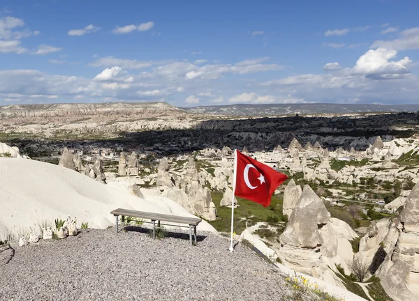 CAPPADOCIA, TURQUÍA - 06 DE MAYO DE 2015: Foto de Bench y la bandera de Turquía al borde del Valle de las Palomas . — Foto de Stock