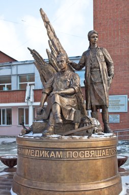 Yekaterinburg, Rusya Federasyonu - 21 Ekim 2015: 4 metre yükseklikte bronz heykel ve 5 ton ağırlığı bir toplu görüntü askeri doktorlar ve hemşireler ağaç arka plan üzerinde kabuk parçaları bölünmüş ve raylar benim.