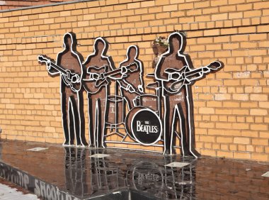Yekaterinburg, Rusya Federasyonu - 21 Ekim 2015: Grup Beatleson bir tuğla duvar siluetleri anıtıdır. Onların önünde ped siyah cilalı Granit kaplı.
