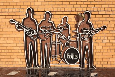 Yekaterinburg, Rusya Federasyonu - 21 Ekim 2015: bir tuğla duvar Beatles grubunun siluetleri anıtıdır. Onların önünde ped siyah cilalı Granit kaplı.