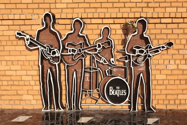 Yekaterinburg, Rusya Federasyonu - 21 Ekim 2015: bir tuğla duvar Beatles grubunun siluetleri anıtıdır. Onların önünde ped siyah cilalı Granit kaplı.