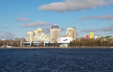 Yekaterinburg, Rusya Federasyonu - 21 Ekim 2015 ile modern yüksek katlı binalar ve gölün kıyısında inşa bir düz yatay bina konser Waterfront kentsel su birikintisi. Sinema ve konser kompleksi 1967 yılında inşa edildi.