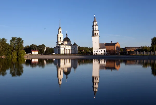 Nevyansk ロシア連邦 2014 ロック 池のほとりの白い建物します 左に斜面を持つ背の高い 尖塔のタワー 柱廊と入り口に列を持つ建物 つのドーム — ストック写真