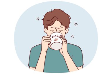 Bardaktan kahve içen bir adam uyanıyor ve zor bir iş gününden önce neşelenmek ve güç kazanmak istiyor. Kafein ve taidrarlı içeceklerle uyanmaya çalışan yorgun genç adam.