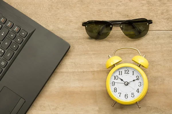 Schwarzes Notizbuch und gelbe Uhr mit Augenglas auf Holz — Stockfoto