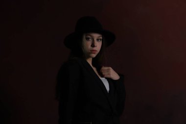 Kırmızı arka planda şapkalı bir genç.