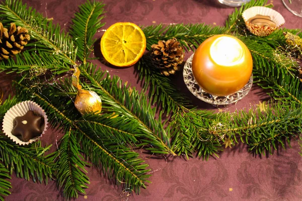 Різдвяні прикраси свічки з ялицею на гілках столових дерев — стокове фото