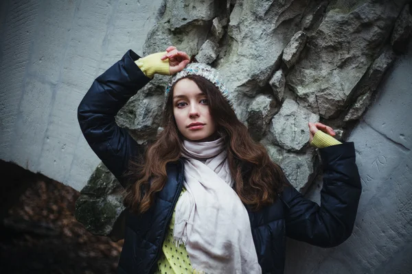 Mooie triest vrouw op koude stenen achtergrond — Stockfoto