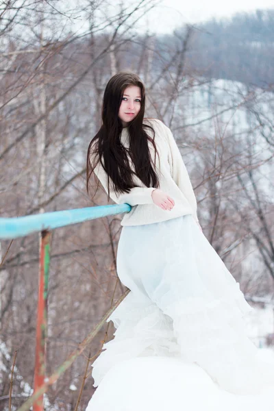 Schöne Frau im weißen Kleid auf Winterlandschaft — Stockfoto