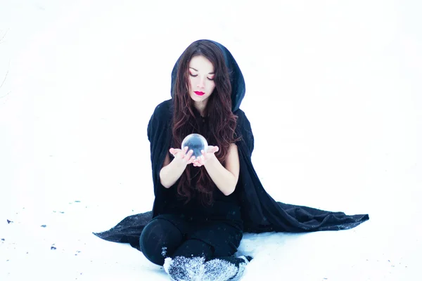 Beautiful witch in black cloak with magiс ball — Stock Photo, Image