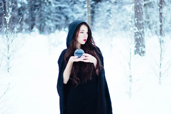 Beautiful witch in black cloak with magiс ball — Stock Photo, Image