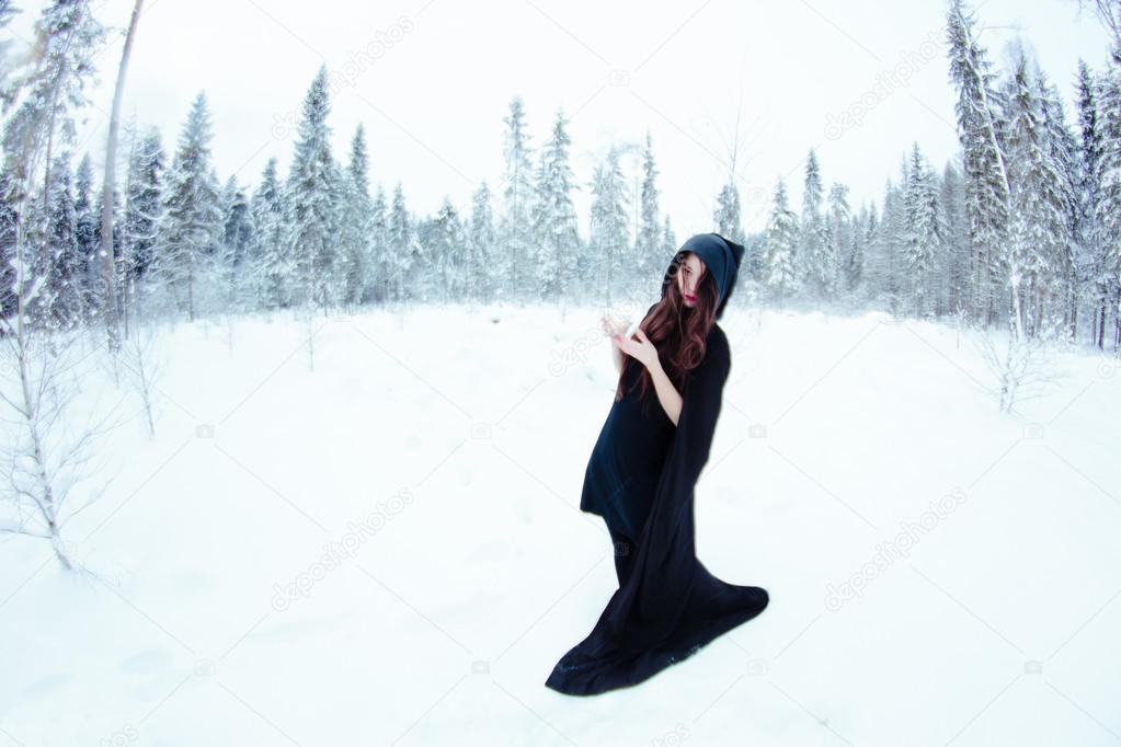 Beautiful witch in black cloak with magiс ball