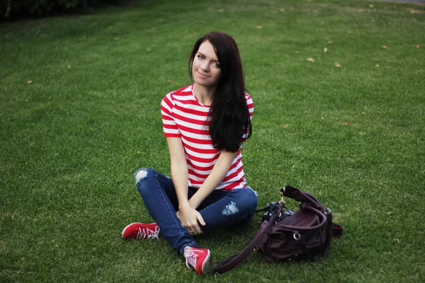 Happy beautiful woman sitting on green field summer — Stok fotoğraf