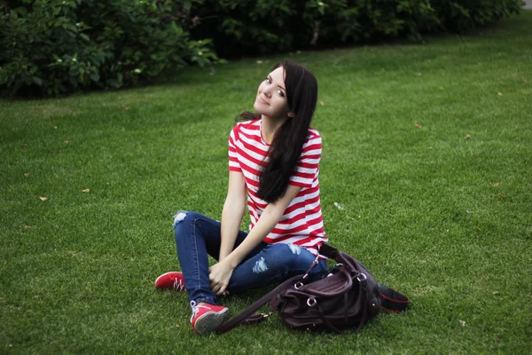 Happy beautiful woman sitting on green field summer — Zdjęcie stockowe