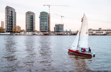 Londra, İngiltere - 17 Nisan 2014: Thames nehrinde bir yelkenli. Nine Elms arka planda, nehir kenarındaki yerleşim yerlerinde gelişmeler var.. 