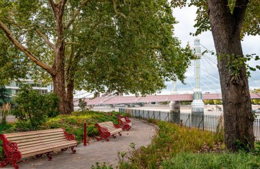İngiltere, Londra 'da Thames nehrinin güney kıyısındaki Battersea Park' tan Albert Köprüsü manzaralı..