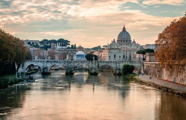 Arka planda Aziz Peter Bazilikası 'nın kubbesi ile Tiber nehri boyunca uzanan Ponte Sant' Angelo (St. Angelo Köprüsü) manzarası.