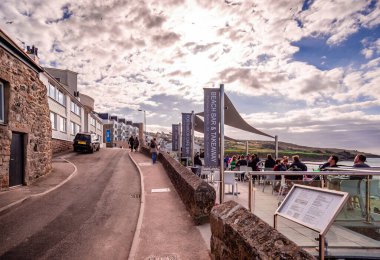 St Ives, İngiltere - 19 Nisan 2014: Digey Flats 'ın rıhtımdaki görüntüsü. Kafe ve barlardaki insanlar Porthmeor plajının tadını çıkarıyorlar..