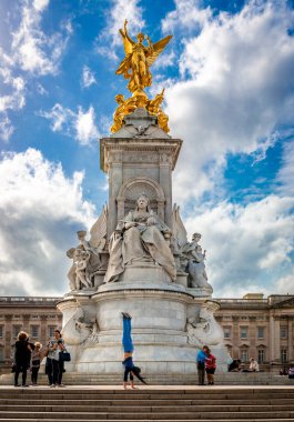 Londra / İngiltere - 20 Eylül 2018: Turistler fotoğraf çekiyor ve Buckingham Sarayı 'nın önündeki The Mall' ın sonunda yer alan Kraliçe Victoria Anıtı önünde amuda kalkıyor.. 