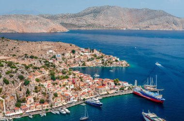 Symi, Yunanistan - 17 Ağustos 2017: Köyün yukarıdan panoramik manzarası. Symi, sakin atmosferi ve muhteşem mimarisi ile ziyaretçileri hayrete düşüren küçük bir Dodecanese adasıdır.. 
