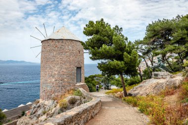 Hydra, Yunanistan - 29 Nisan 2018: Hydra limanından Kaminia 'ya uzanan patikada bulunan eski geleneksel yel değirmeni.
