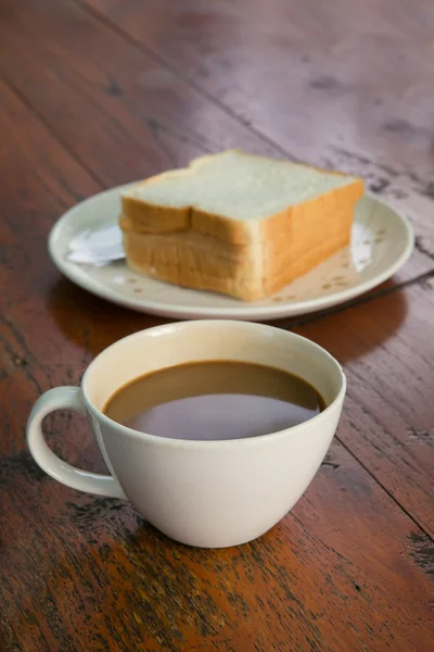 Šálek kávy s plátky chleba na dřevěný stůl — Stock fotografie