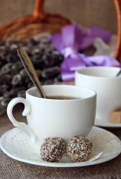 Tea in a white cup and saucer and candy. — Stock Photo, Image