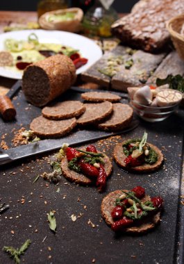 Tahıl ekmeği ve masanın üzerine farklı baharatlar.