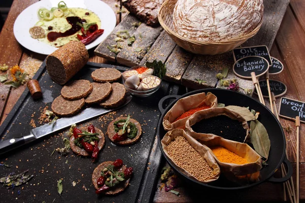 Зерновой хлеб и различные специи на столе . — стоковое фото
