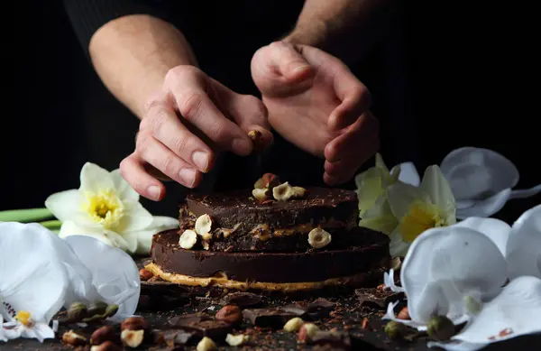 Pastel de chocolate en un plato, que está decorado con avellanas cocinero . — Foto de Stock