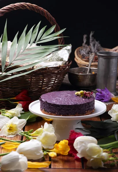 Gâteau sur une assiette, debout sur la table parmi les fleurs du printemps . — Photo