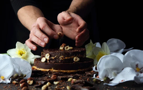 Gâteau au chocolat sur une assiette, qui est décoré de noisettes cuisinier . — Photo