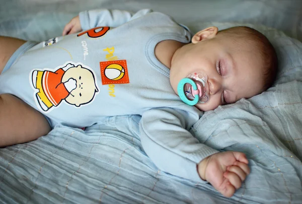 O menino está dormindo na cama . — Fotografia de Stock