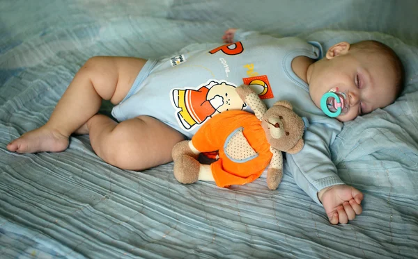 O menino está dormindo na cama . — Fotografia de Stock