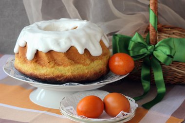 Bir tabak ve masada boyalı yumurta Paskalya kek.