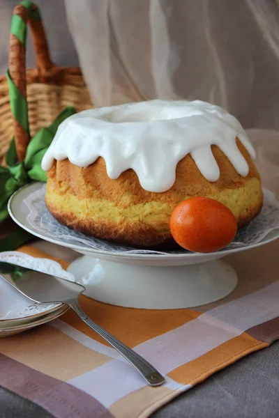 Пасхальный торт на тарелке и разрисованные яйца на столе . — стоковое фото