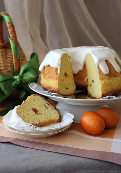 Torta di Pasqua, tagliata a pezzi su un piatto e uova dipinte sul tavolo . — Foto Stock