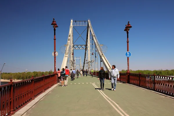 Uma vista da ponte pedonal e pessoas passeando nele — Fotografia de Stock