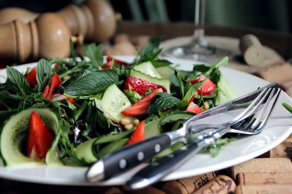 Spicy salad of strawberries and cucumber seasoned with herbs and sauce. — Stock Photo, Image