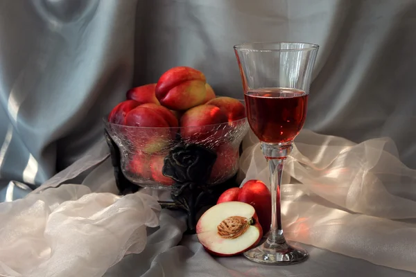 Een glas champagne en nectarines. — Stockfoto